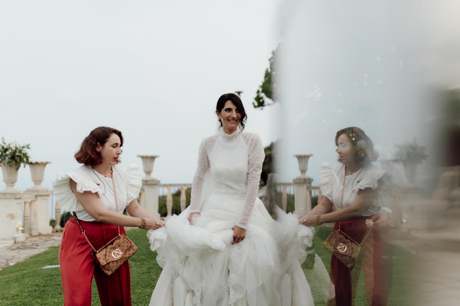 Francesca Tiene il vestito alla Sposa mentre cammina in giardino
