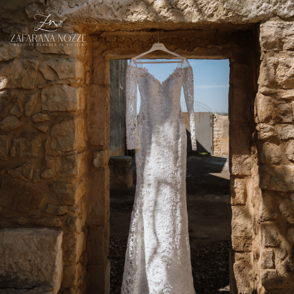 abito da sposa in pizzo appeso alla parete
