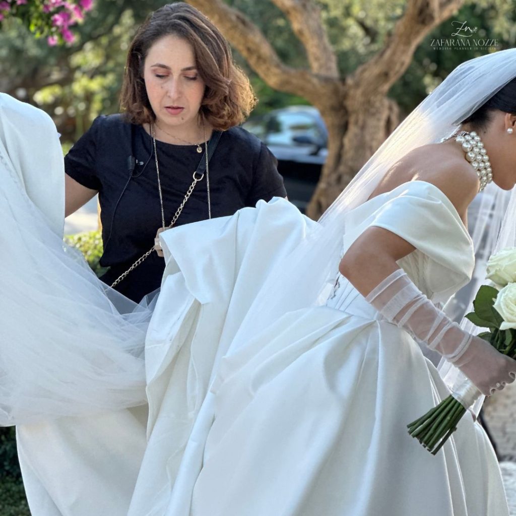 sposa francesca che le tiene il velo mentre si preparare a salire in macchina