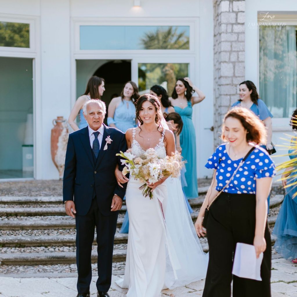 la sposa con il padre sotto braccio e francesca davanti la wedding planner